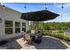 Outdoor patio with stone pavers, outdoor table, umbrella, grill, and string lights at 2124 Gaddis Rd, Canton, GA 30115
