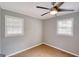 A bedroom featuring neutral paint, two windows, a ceiling fan, and tile flooring at 1236 Stone Mountain Lithonia Rd, Lithonia, GA 30058