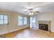 Living room with hardwood floors, a stone fireplace, ceiling fan, and natural light from the windows at 1236 Stone Mountain Lithonia Rd, Lithonia, GA 30058