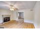 Spacious living room with hardwood floors, a stone fireplace and a ceiling fan at 1236 Stone Mountain Lithonia Rd, Lithonia, GA 30058