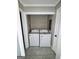 Bright laundry closet with gray tile floor and side by side washer and dryer at 4712 Rockstile Way, Stone Mountain, GA 30083