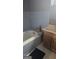 This bathroom features blue tile, a classic tub, and traditional vanity, ready for updates at 4064 Sunset Sw Dr, Atlanta, GA 30331