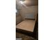 An empty bedroom features a wooden platform bed frame and tiled floors at 4064 Sunset Sw Dr, Atlanta, GA 30331