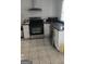 Bright kitchen featuring stainless steel appliances, white cabinets, dark countertops, and tile flooring at 4064 Sunset Sw Dr, Atlanta, GA 30331
