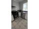 Corner view of a kitchen featuring stainless steel appliances, white cabinets, and tile floors at 4064 Sunset Sw Dr, Atlanta, GA 30331