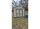 Backyard view of a gray and cream-colored storage shed with a double door, providing convenient outdoor storage at 4064 Sunset Sw Dr, Atlanta, GA 30331
