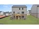Rear exterior view of a home with a wooden deck, lawn, and freshly planted sapling trees at 588 Whitman Ln # 23, Stockbridge, GA 30281