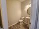 Clean bathroom with stylish pedestal sink, round mirror and wood-look flooring at 883 Ironhorse Sw Ln, Mableton, GA 30126