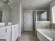 Bright bathroom showcasing a double vanity, soaking tub, and a separate glass enclosed shower at 883 Ironhorse Sw Ln, Mableton, GA 30126