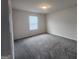 Sunny bedroom features neutral paint, carpet, and a large window at 883 Ironhorse Sw Ln, Mableton, GA 30126