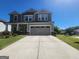 Two-story home with a gray exterior, well-manicured lawn, and a two-car garage on a clear, sunny day at 883 Ironhorse Sw Ln, Mableton, GA 30126