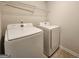 A laundry room features a white washer and dryer with a wire rack shelf at 883 Ironhorse Sw Ln, Mableton, GA 30126