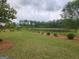 Scenic pond surrounded by lush landscaping, green grass, and a bench at 883 Ironhorse Sw Ln, Mableton, GA 30126