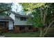 Two-story home with vinyl siding and a brick foundation, nestled among mature trees at 3296 Columbia Woods Dr, Decatur, GA 30032