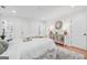 Well-lit bedroom with white bedding, mirrored accent cabinet, and a view of the bathroom at 4327 Welligton Hill Ln, Snellville, GA 30039