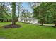 Lovely white home with shutters has an attached garage, a large grassy yard, and beautiful mature trees at 4327 Welligton Hill Ln, Snellville, GA 30039