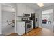 Well-lit kitchen boasts stainless steel appliances, white cabinets, and hardwood floors at 4811 Nevilly Way, Marietta, GA 30066