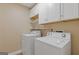 Functional laundry room with white cabinetry, shelving, and modern washer and dryer at 4811 Nevilly Way, Marietta, GA 30066