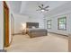 Primary bedroom featuring a tray ceiling, carpet floors, and a large comfortable bed at 120 Hermitage Pl, Peachtree City, GA 30269