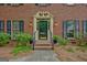 Inviting front door with decorative trim, sconces, black hardware, and well-maintained landscaping at 120 Hermitage Pl, Peachtree City, GA 30269