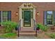 Charming front door with an ornate frame, black iron railings, and potted plants on a brick step at 120 Hermitage Pl, Peachtree City, GA 30269