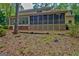 Large screened-in porch overlooking a private backyard with a tree-lined perimeter at 120 Hermitage Pl, Peachtree City, GA 30269