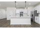 Open concept kitchen with white cabinets, large island, modern lighting, and stainless appliances at 432 Cantrell Drive, Dallas, GA 30157