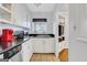 Compact kitchen featuring white cabinetry, black countertops, and tile flooring at 300 Peachtree Ne Ave # 22N, Atlanta, GA 30305