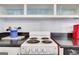 Close up on the functional stove top with white cabinets, black countertops and a pop of red at 300 Peachtree Ne Ave # 22N, Atlanta, GA 30305
