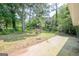 Expansive backyard featuring mature trees, wooden structures, and a concrete patio, creating a peaceful outdoor retreat at 4806 Rockbridge Rd, Stone Mountain, GA 30083
