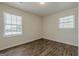 This light-filled bedroom features new wood-look flooring and two windows with charming views at 4806 Rockbridge Rd, Stone Mountain, GA 30083