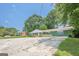 Charming ranch-style home with a painted brick facade, a front porch with wooden railings, and a spacious concrete parking area at 4806 Rockbridge Rd, Stone Mountain, GA 30083