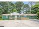 Charming ranch-style home with a painted brick facade, a front porch with wooden railings, and a spacious concrete parking area at 4806 Rockbridge Rd, Stone Mountain, GA 30083