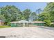 Charming ranch-style home with a painted brick facade, a front porch with wooden railings, and a spacious concrete parking area at 4806 Rockbridge Rd, Stone Mountain, GA 30083