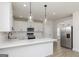 Bright kitchen features white cabinets, stainless steel appliances, and a spacious island with pendant lighting at 412 Cantrell Drive, Dallas, GA 30157