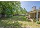View of the backyard featuring green grass, fenced yard, patio with a covered area at 5045 Edinborough Pl, Sugar Hill, GA 30518