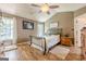 Comfortable bedroom with wood floors, a ceiling fan, and ample natural light from the windows at 5045 Edinborough Pl, Sugar Hill, GA 30518