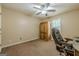 Bedroom with brown carpet, ceiling fan, window and wooden cabinet and executive chair at 5045 Edinborough Pl, Sugar Hill, GA 30518
