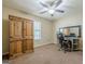 Bedroom with brown carpet, ceiling fan, window and wooden cabinet, desk and executive chair at 5045 Edinborough Pl, Sugar Hill, GA 30518