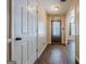 Hallway features wood floors and neutral walls leading to the front door and an adjacent room with a large window at 5045 Edinborough Pl, Sugar Hill, GA 30518