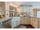 Well-lit kitchen featuring granite countertops, a farmhouse sink, and custom cabinetry for ample storage space at 5045 Edinborough Pl, Sugar Hill, GA 30518