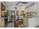 Kitchen features stainless appliances, granite countertops, and white cabinets in an open floor plan with hardwood flooring at 5045 Edinborough Pl, Sugar Hill, GA 30518