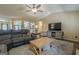 Bright and open living room featuring comfortable seating, a large TV, and an open view of the kitchen area at 5045 Edinborough Pl, Sugar Hill, GA 30518