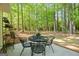 Backyard patio featuring a wrought iron table with seating for four and a view of the wooded yard at 140 Braymoor Cir, Fayetteville, GA 30215