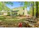 Large backyard featuring a home with yellow siding, a patio, a grill, and a wooded view at 140 Braymoor Cir, Fayetteville, GA 30215