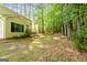Large backyard featuring a home with yellow siding, a patio, and a wooded view at 140 Braymoor Cir, Fayetteville, GA 30215