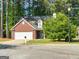 Exterior shot of a single Gathering home with a two car garage and brick and vinyl siding at 140 Braymoor Cir, Fayetteville, GA 30215
