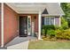 Charming brick home featuring a covered front porch with column, manicured landscaping, and a screen door at 140 Braymoor Cir, Fayetteville, GA 30215