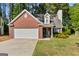 Charming brick home featuring a two-car garage, manicured lawn, and lovely landscaping at 140 Braymoor Cir, Fayetteville, GA 30215