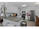 Modern kitchen featuring stainless steel appliances, granite countertops, and white cabinetry at 140 Braymoor Cir, Fayetteville, GA 30215